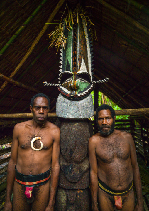 Portrait of chieftain Sekor and his father in front of a painted grade statue, Ambrym island, Olal, Vanuatu