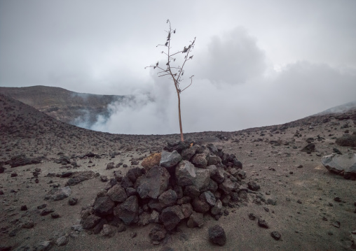 Grave in front of an eruption at the top of mt Yasur volcano, Tanna island, Mount Yasur, Vanuatu
