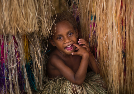 Girl hiding in the grass skirt of her mother, Tanna island, Yakel, Vanuatu