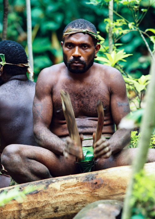 Tribesman beating a drum during a ceremony in the jungle, Malampa province, Malekula island, Vanuatu