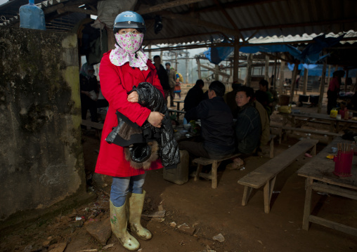 Elegant woman with a crash helmet and a scarf on the face, Sapa market, Vietnam