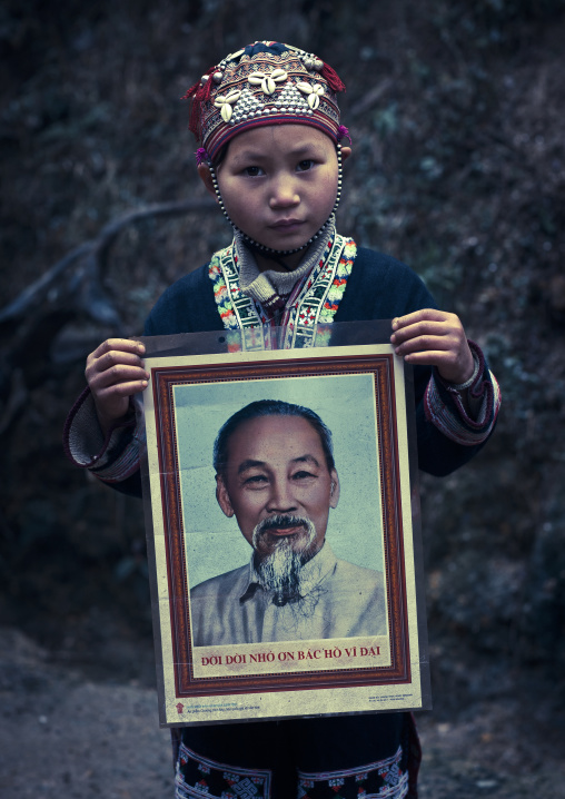 Young red dzao girl showing the portrait of ho chi minh, Sapa, Vietnam