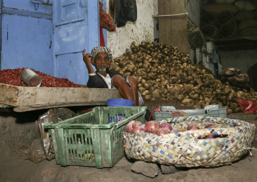 Seller Sitting On The Ground Among His Goods At Al Hodeidah Souq, Yemen