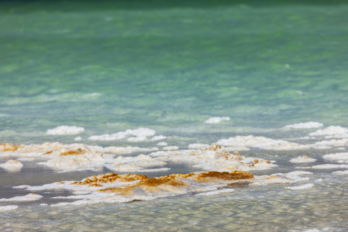 Waves deposit salt crystals along the rippling shore of Lake Assal, Dikhil Region, Lake Assal, Djibouti