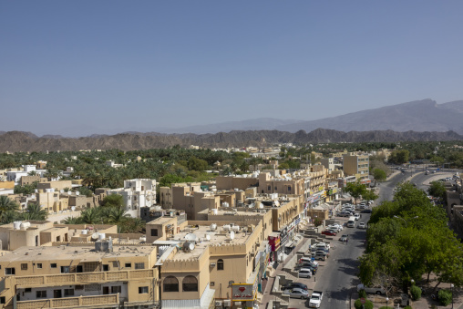 Elevated view of Nizwa town with palm groves buildings and mountains in the background, Ad Dakhiliyah Region, Nizwa, Oman