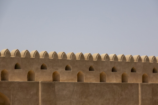 Close-up of the crenellated battlements and arrow slits along the walls of Nizwa Fort, Ad Dakhiliyah Region, Nizwa, Oman