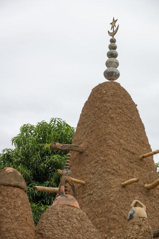 A crescent-topped spire rises above a small clay figure at the 17th-century Sudano-Sahelian mosque, Savanes district, Kouto, Ivory Coast