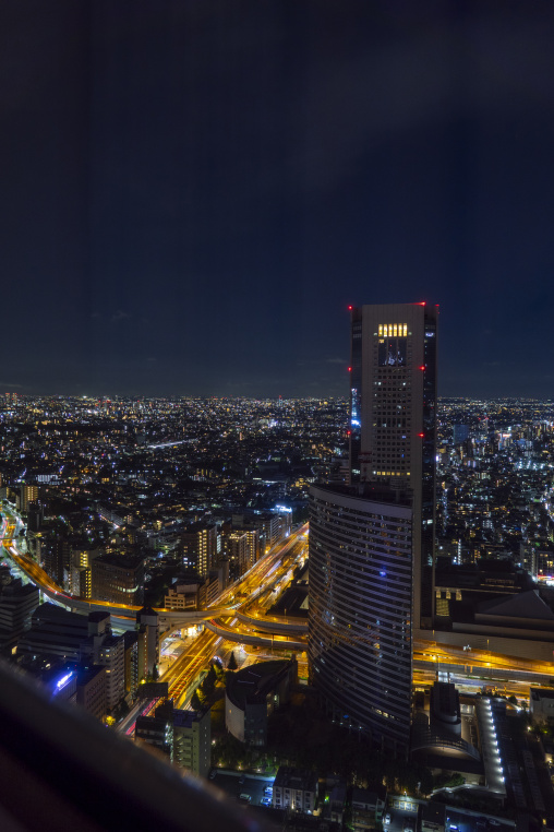 Aerial night view of Tokyo skyscrapers and an illuminated highwa