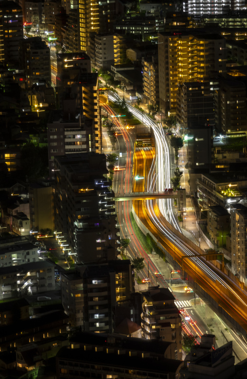 Long exposure night view of a curving road with traffic light tr