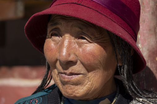 Tibetan woman wearing a traditional red hat, Tongren County, Longwu, China