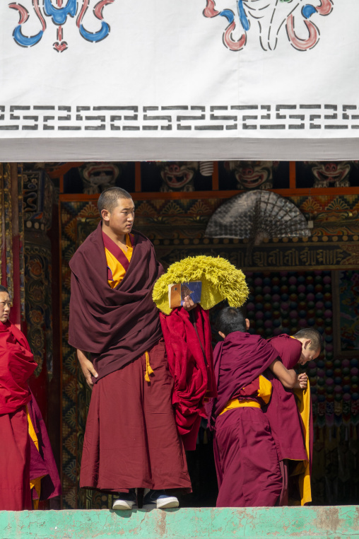 Tibetan monks of the Gelug or Yellow Hat sect gather on the steps of the assembly hall at Bongya monastery, Qinghai Province, Mosele, China
